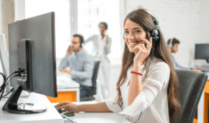 young female customer service agent smiling while taking a call and helping a customer