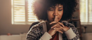 young woman sits with eyes closed in peaceful meditation