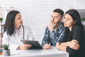 doctor going over treatment plan with troubled young couple