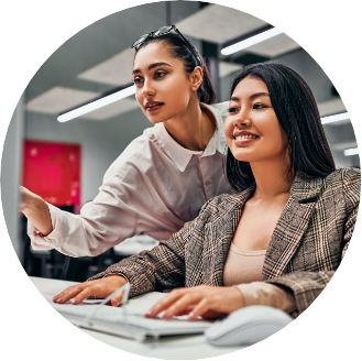 two young female finance professionals working at a computer