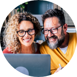 happy mature couple looking at laptop while video-conferencing