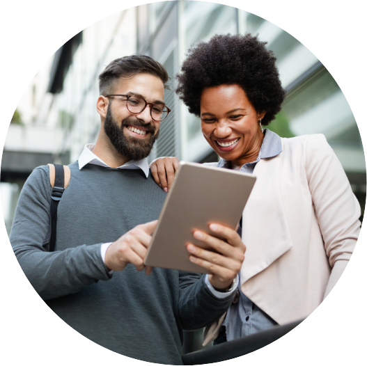 man and woman looking at a tablet together and smiling