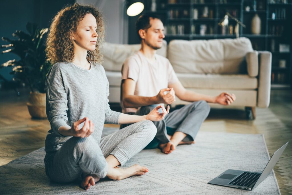 couple practicing meditation in living room