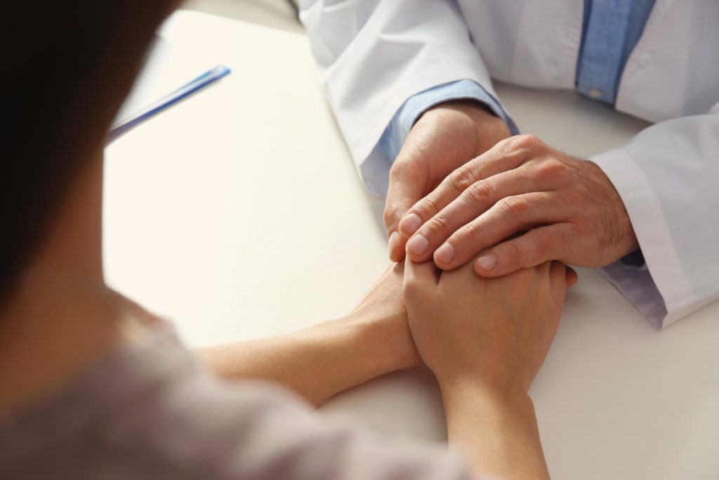 a doctor comforts a patient during an addiction screening for rehab admission