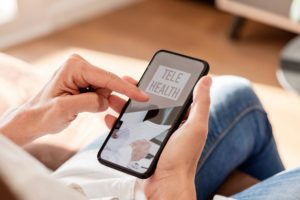 a client prepares for a telehealth visit via smartphone at home