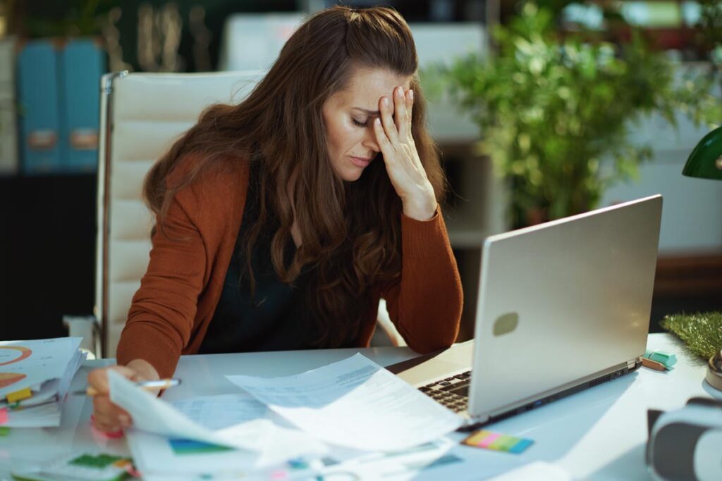 a person looks stressed while encountering common issues in behavioral health documentation and charting on a computer
