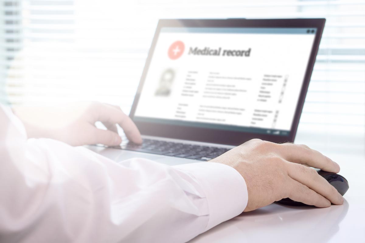 a person reviews medical records on a computer possibly wondering when to change your emr