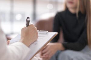 a therapist takes notes in person-first language in a behavioral healthcare appointment