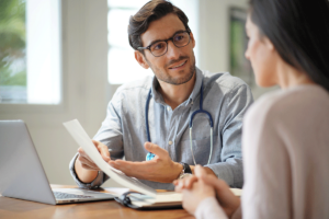 a provider holds a paper while explaining the importance of sharing data with patients to someone