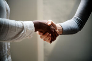 two people shake hands after discussing the benefits of a customer relationship management tool