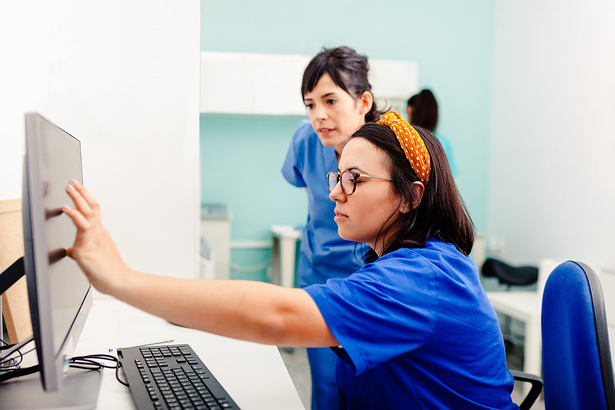 two nurses review a computer screen after learning of the importance of behavioral health electronic medical records