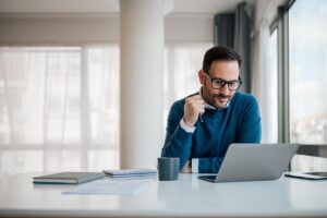 a person uses a computer to research how alumni management increases recovery success