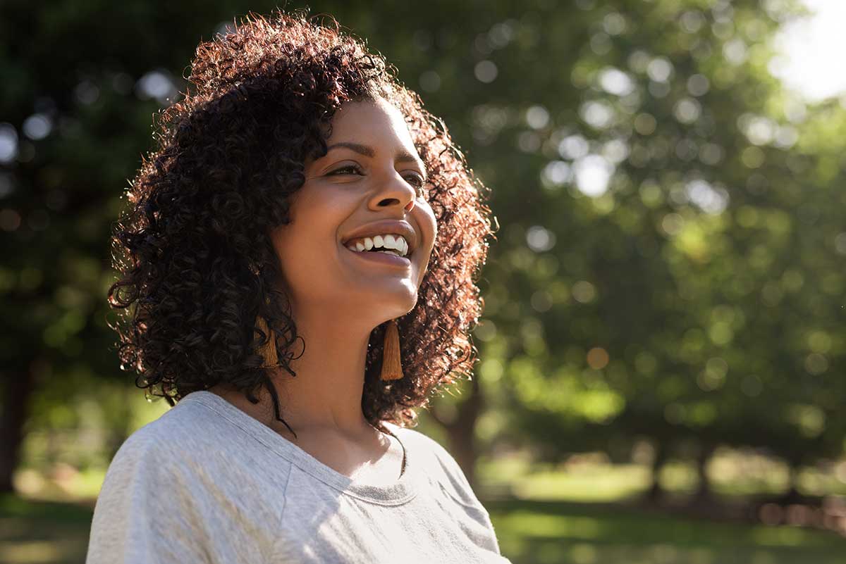 a woman smiles after learning how to use emr data to improve treatment