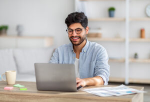 a man uses a computer to research how to streamline admissions process in rehab centers